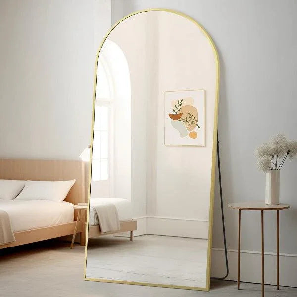 Arched gold full length floor mirror shown in a room setting