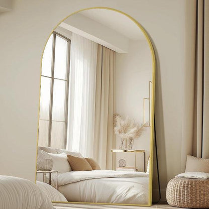 Arched full length mirror with gold frame in bedroom