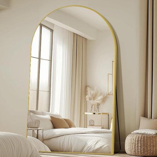 Arched full length mirror with gold frame in bedroom