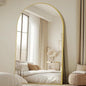 Arched full length mirror with gold frame in bedroom
