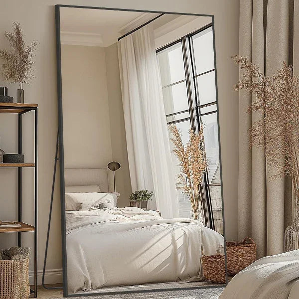 Rectangular floor mirror leaning against wall