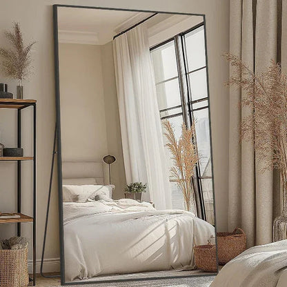 Rectangular floor mirror leaning against wall