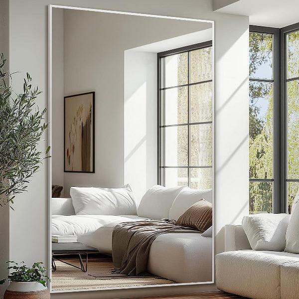 Silver floor mirror viewed at an angle against a plain background
