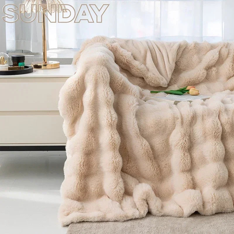 Plush faux fur throw blanket on bed