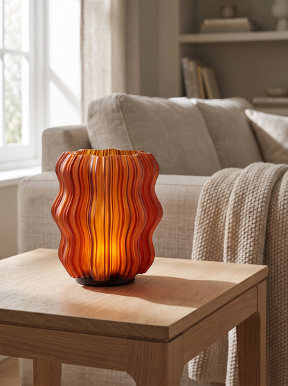 Close three quarter view of the Cordless Mini Wavy Lamp showing its ribbed wavy surface on a pale oak side table