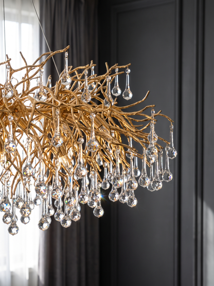 Close view of the branching gold arms and cut crystal drops of the crystal ceiling chandelier