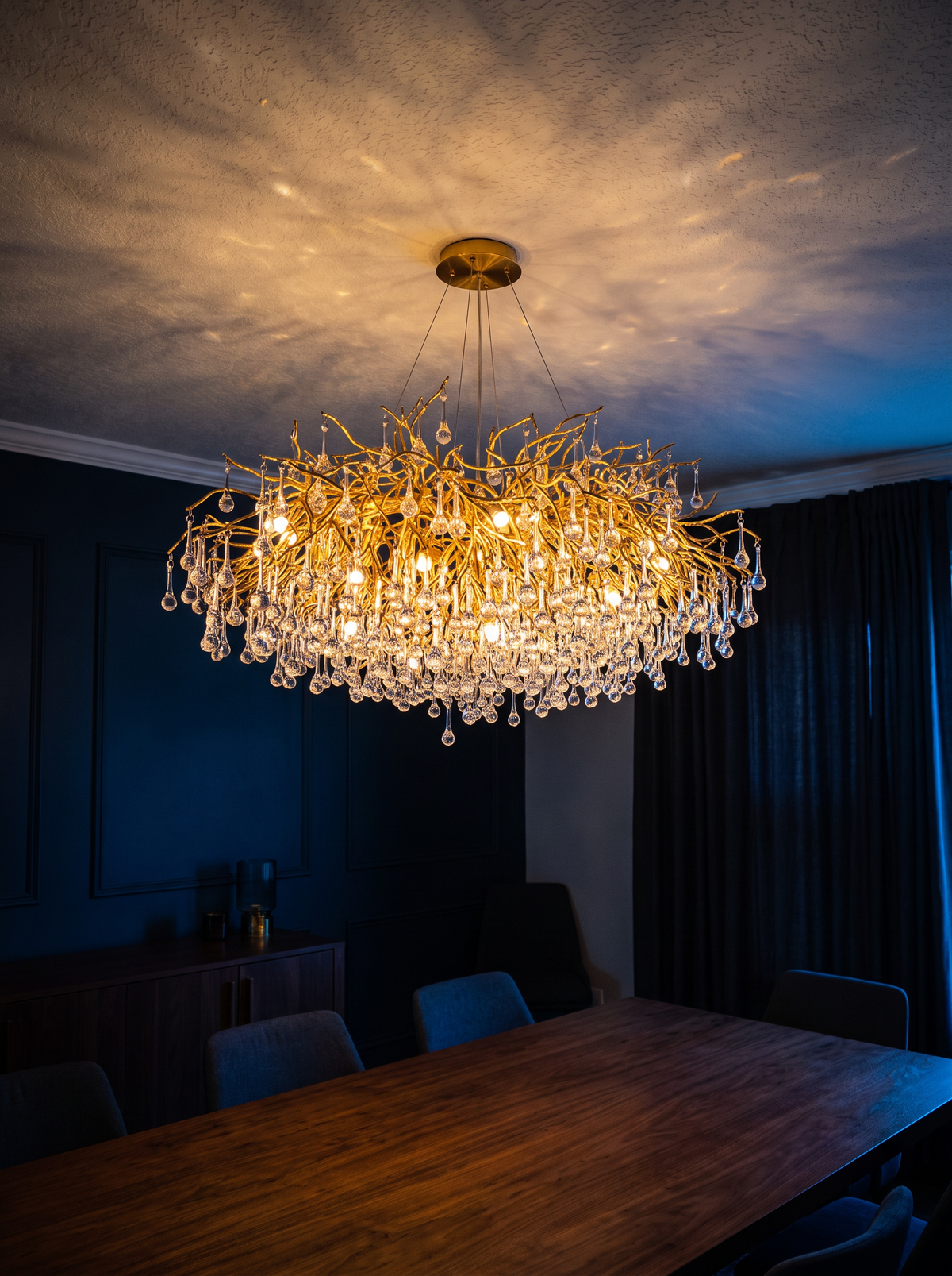 Crystal ceiling chandelier glowing at dusk seen from across the dining room